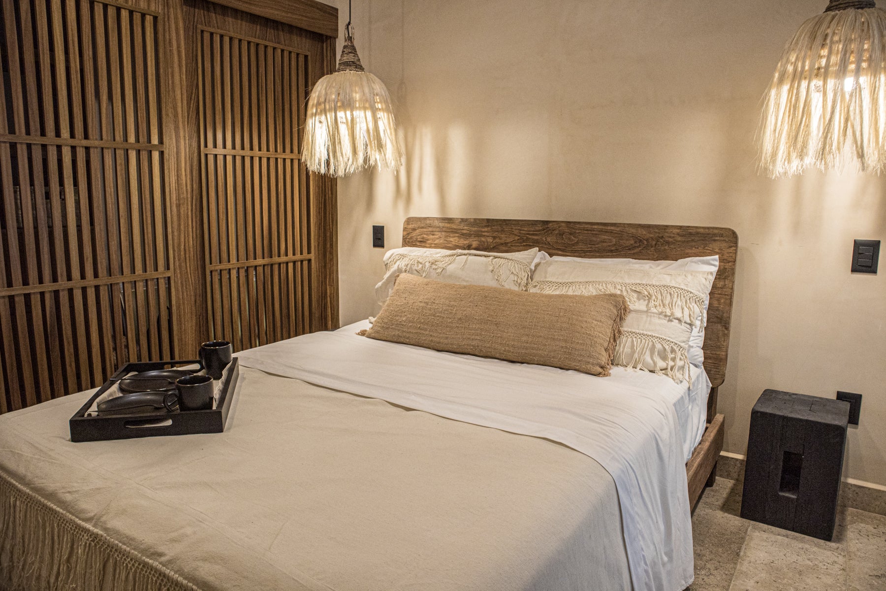 cama king size de madera con lámpara de techo tejida con fibras naturales, buró de madera y cojines decorativos cama king size de madera con lámpara de techo tejida con fibras naturales, buró de madera y cojines decorativos