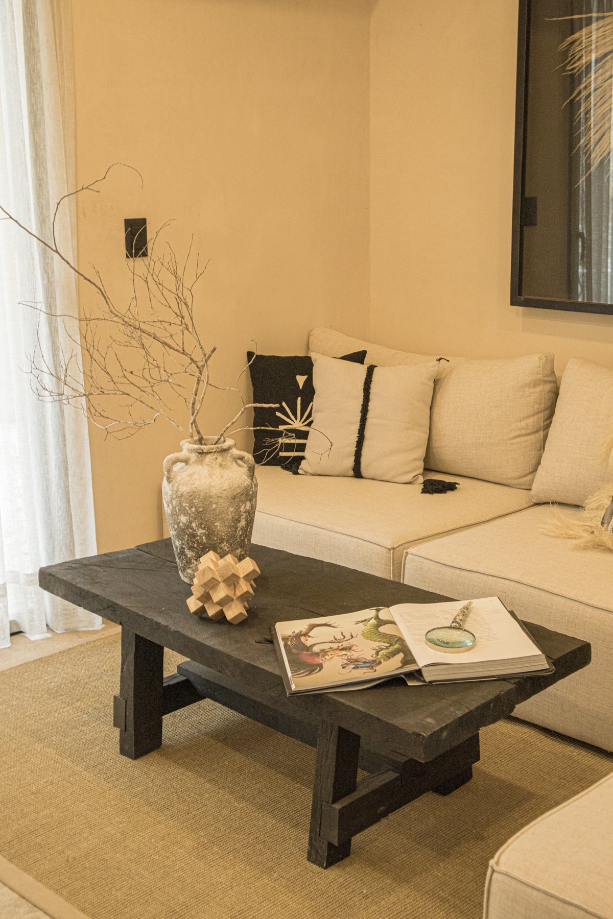 Sala decorada con mesa de centro vintage de madera, sofá en tonos neutros y detalles costeros. Encuentra muebles únicos en Prisma Muebles Tulum.