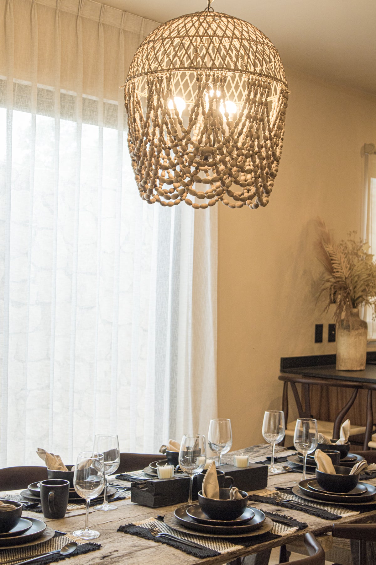 Comedor con sillas para comedor, mesa de madera amplia y lámpara de techo que destacan el diseño costero. Prisma Muebles, tu mueblería en Tulum para casas en la playa.