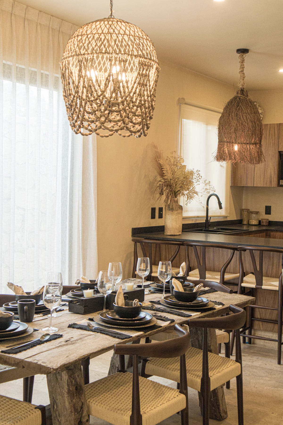 Comedor de 6 sillas, con una mesa vintage de madera y sillas tejidas. Iluminado con lámparas colgantes de diseño artesanal. Y bancas de madera de barra tejidas. Ideal para tu casa de playa, encuéntrala en Prisma Muebles, mueblería en Tulum.