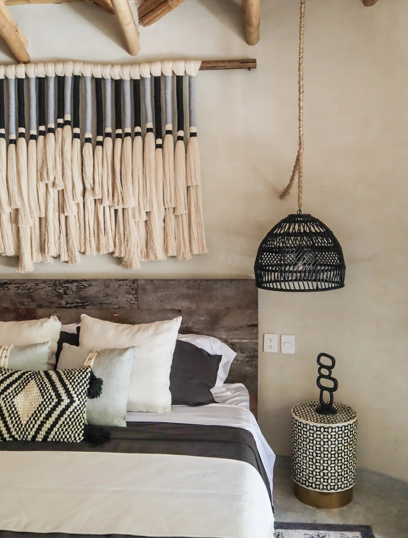 Recámara king size con cabecera rústica y textiles neutros, ideal para casas en Cancún, Playa del Carmen o Tulum