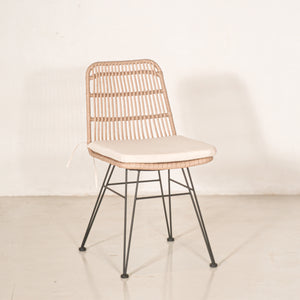 Vista isométrica de Silla de comedor Guyana con base metálica 5/8", antiderrapantes y asiento de rattan sintético impermeable. Cuenta con cojín tapizado en tela color beige. Vista isométrica de Silla de comedor Guyana con base metálica 5/8", antiderrapantes y asiento de rattan sintético impermeable. Cuenta con cojín tapizado en tela color beige.