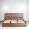 Base y cabecera para cama king size en melamina color nogal. Con patas de madera maciza, soportes para colchón, herrajes metálicos y pata central para mayor resistencia. Encuéntrala en Prisma Muebles, mueblería en Cancún, Playa del Carmen y Tulum.