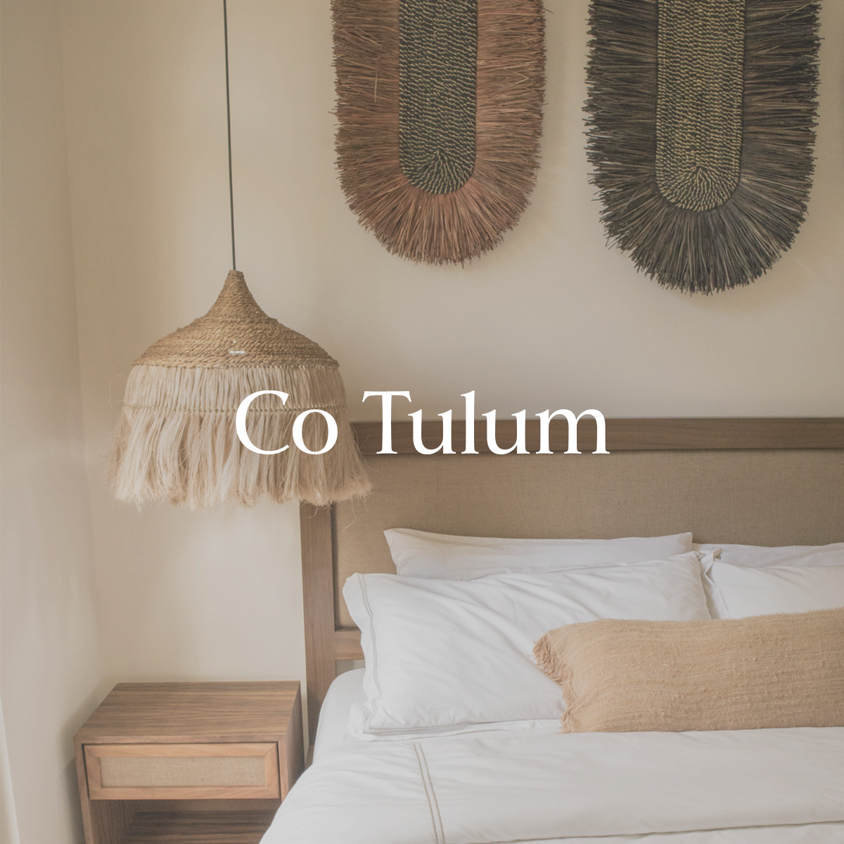 Recamara con ropa de cama de lino, buro de cama y lampara colgante.