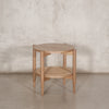 Mesa lateral redonda de madera clara con entrepaño inferior de ratán tejido, ideal para salas o recámaras con estilo natural y tropical | Prisma Muebles.