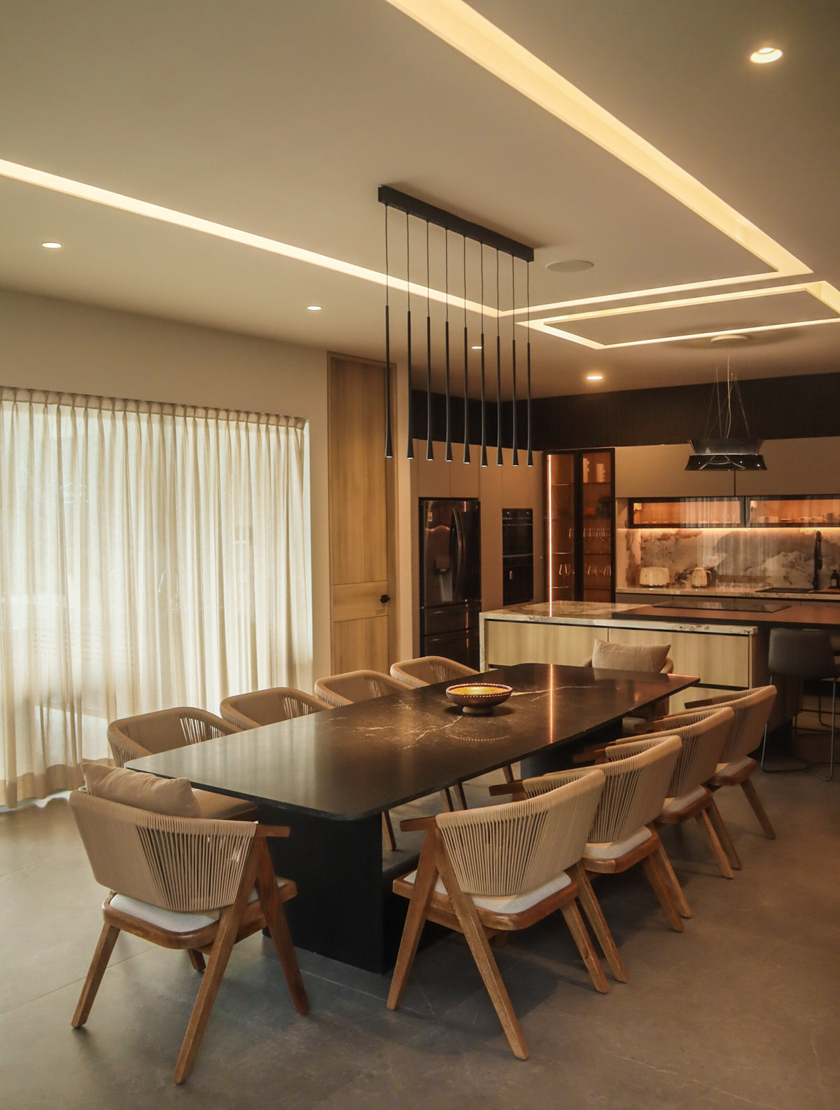 Comedor, sillas de madera tejida y lámpara de techo minimalista, perfecto para casas vacacionales en Cancún, Playa del Carmen y Tulum.
