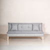 Sofá Cama Confi tapizado en tela Suede Gris, mostrado en su modo de sofá con cojines decorativos en una sala moderna de Prisma Muebles.

